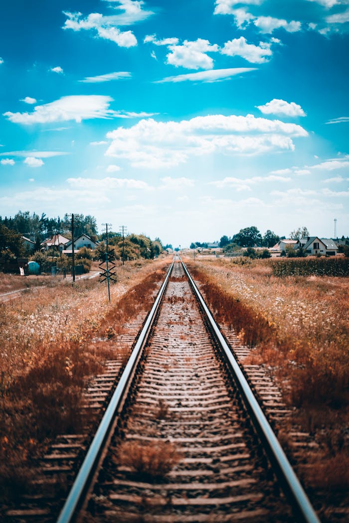 Mastering the First Impression: Your intriguing post title goes here Endless railway tracks stretch through rural landscape under bright sky.