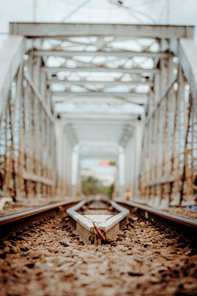 Detailed view of a railway track running through a steel bridge with intricate geometry.