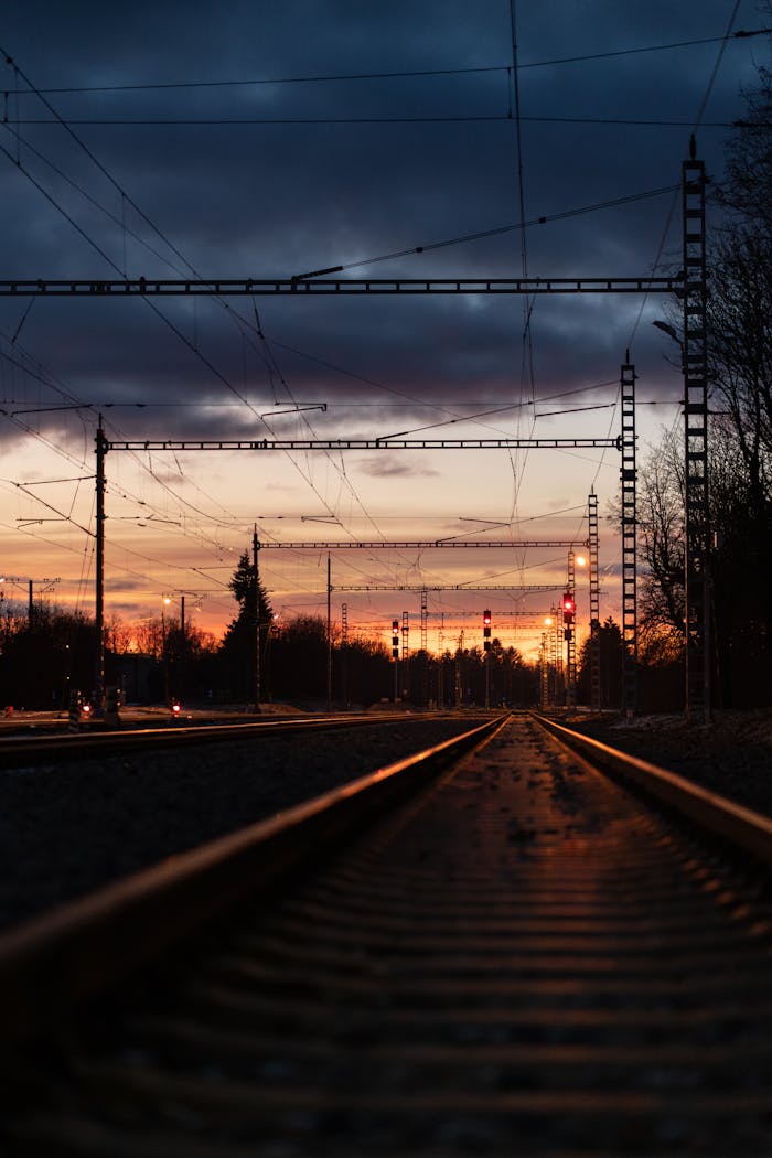 Dramatic railway scene at sunset with vibrant skies, leading lines, and industrial elements.